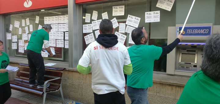 Membres de la PAH Maresme Nord enganxant cartells al Santander aquest matí